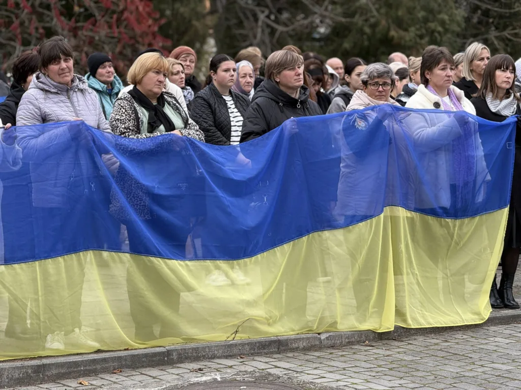 Люди тримають великий прапор України на вулиці