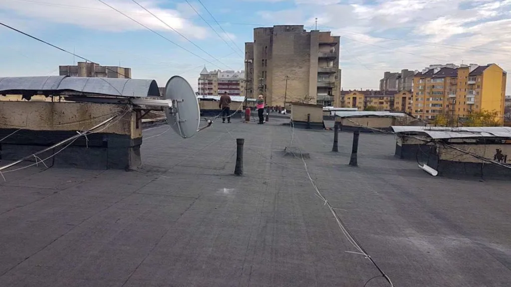 Люди на даху багатоповерхівки з антенами