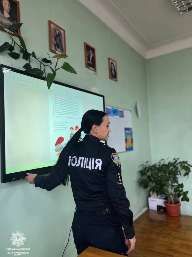 Поліцейська проводить урок у класі біля екрана