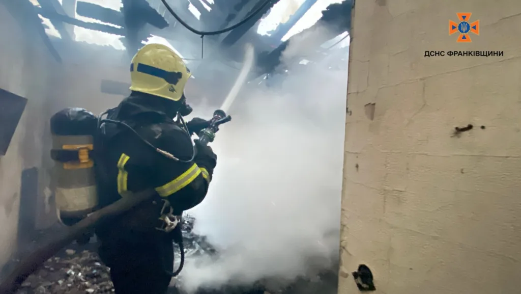 Пожежник гасить вогонь у задимленій будівлі