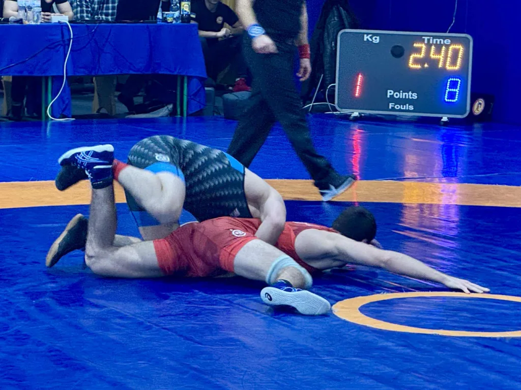 Боротьба двох спортсменів на синьому килимі