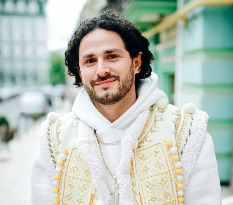 Чоловік у вишитому одязі стоїть на вулиці