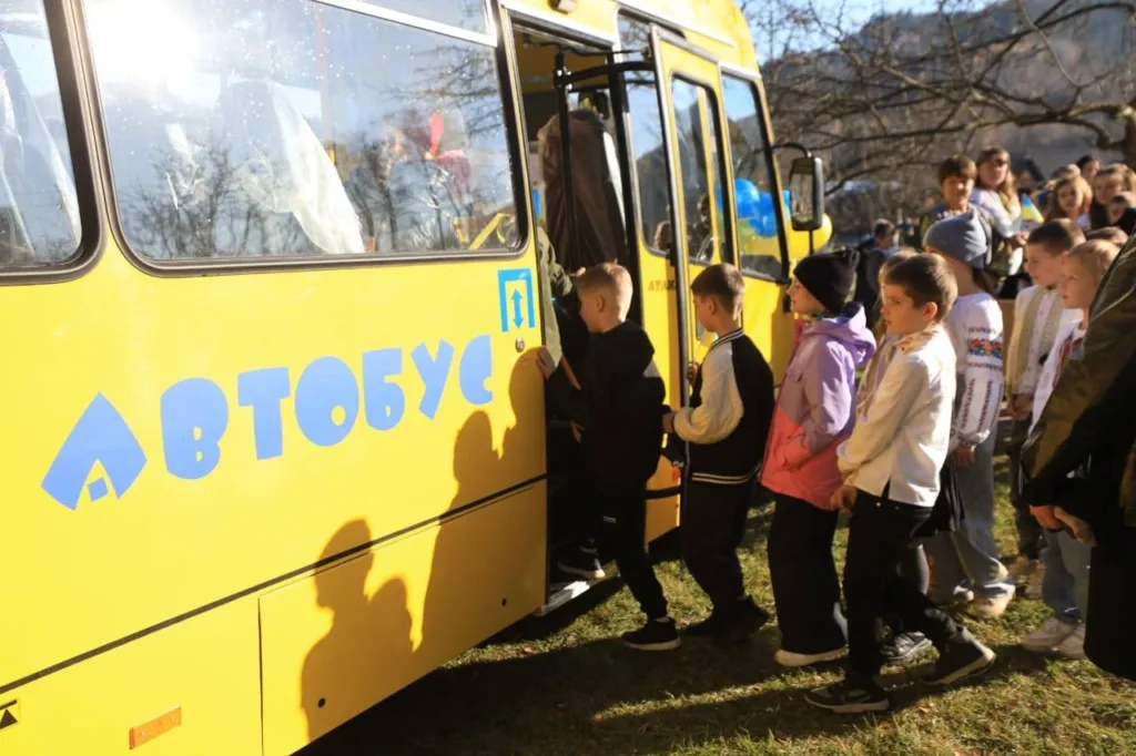 Діти заходять до жовтого шкільного автобуса