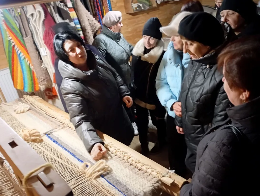 Жінка показує процес ткацтва групі людей