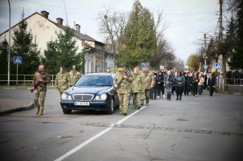 Військовий похорон і колона людей у місті