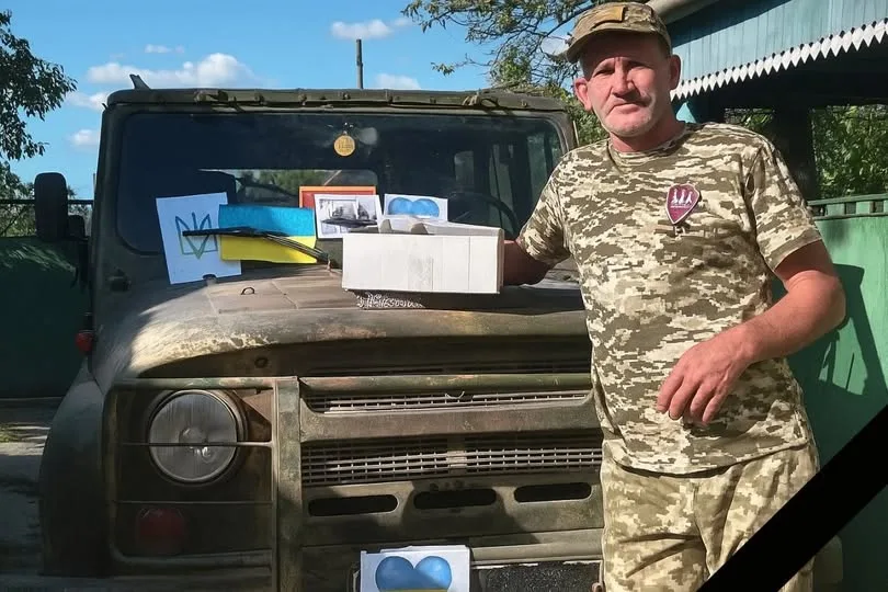 Військовий стоїть біля позашляховика з посилками