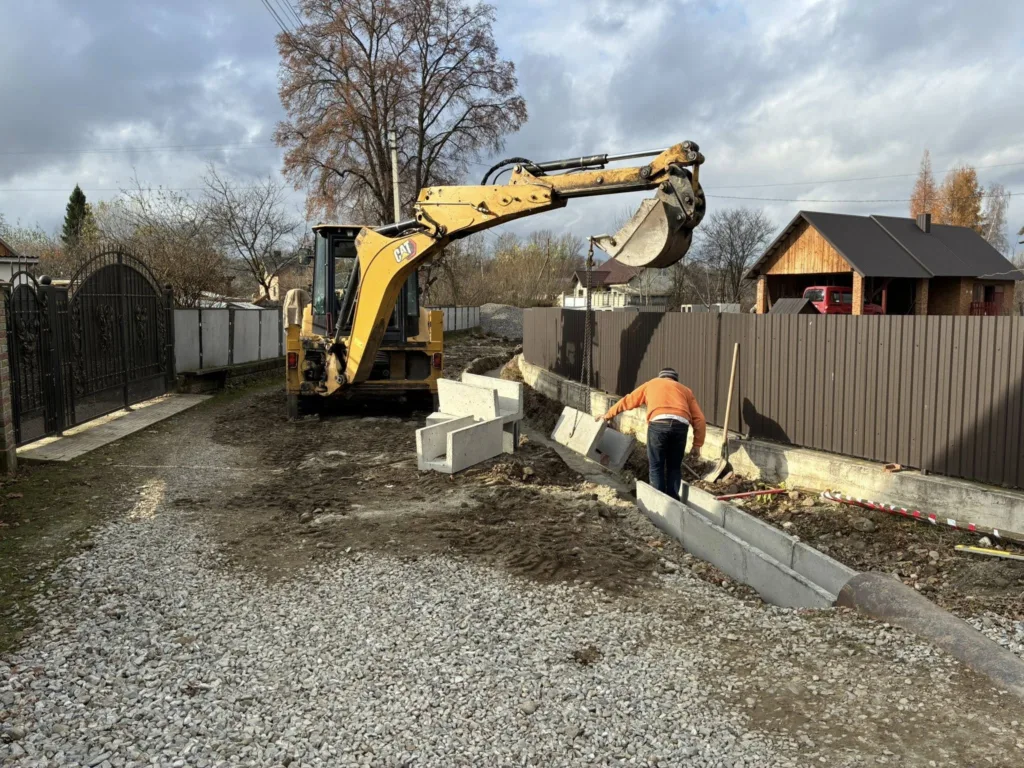 Будівництво дороги екскаватором біля приватного будинку