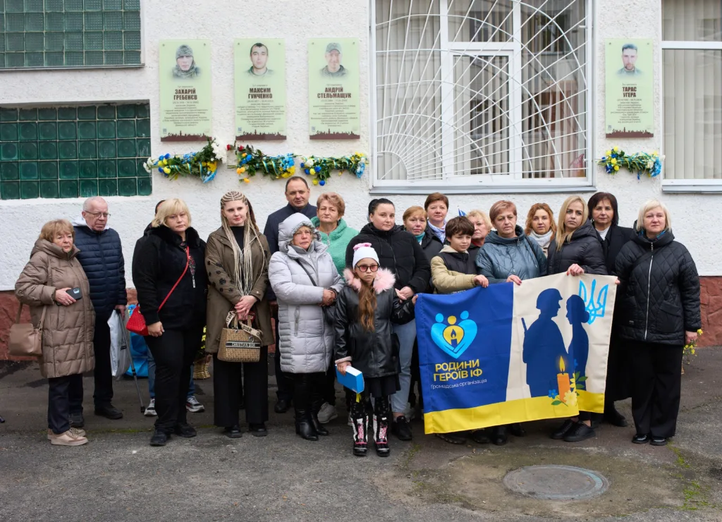 Група людей біля меморіальних дошок героїв України