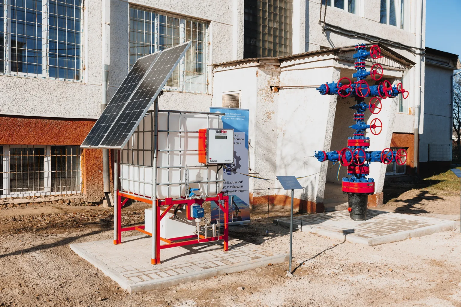 Сонячна панель та нафтогазове обладнання біля будівлі