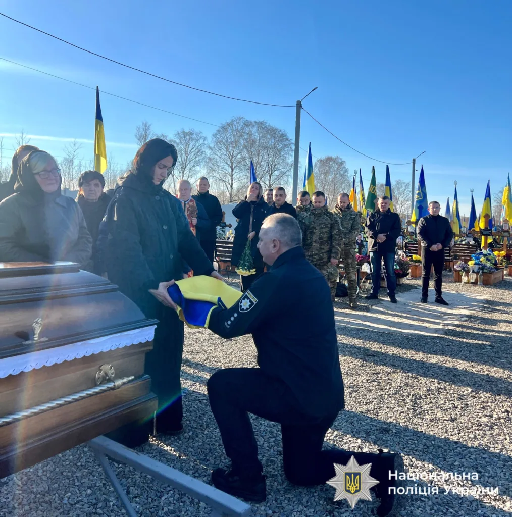 Поліцейський передає прапор на церемонії похорону