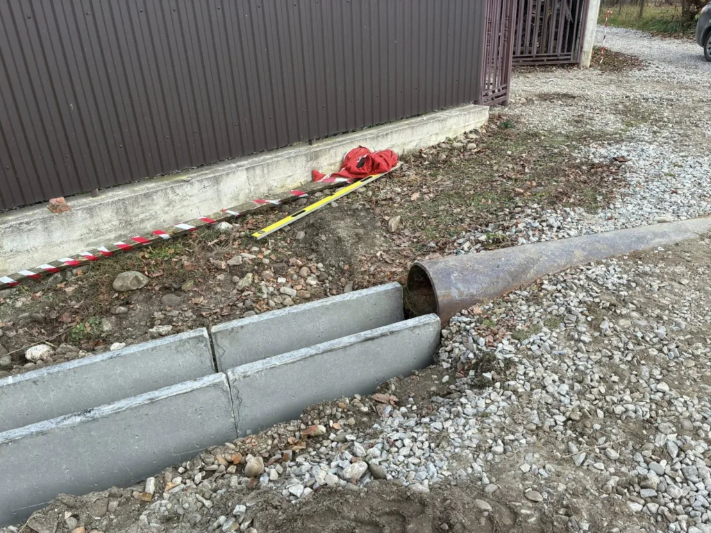 Будівництво водостоку біля паркану приватного будинку