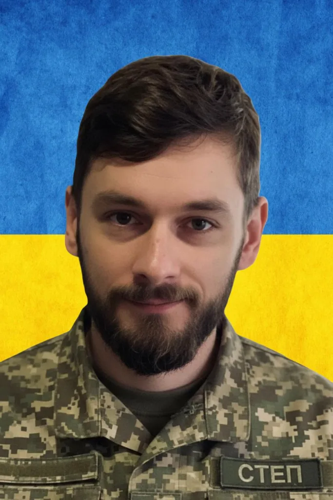 Військовий у формі перед прапором України