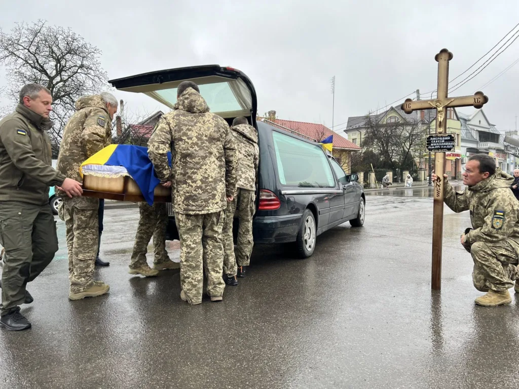 Військові прощаються із загиблим побратимом під дощем
