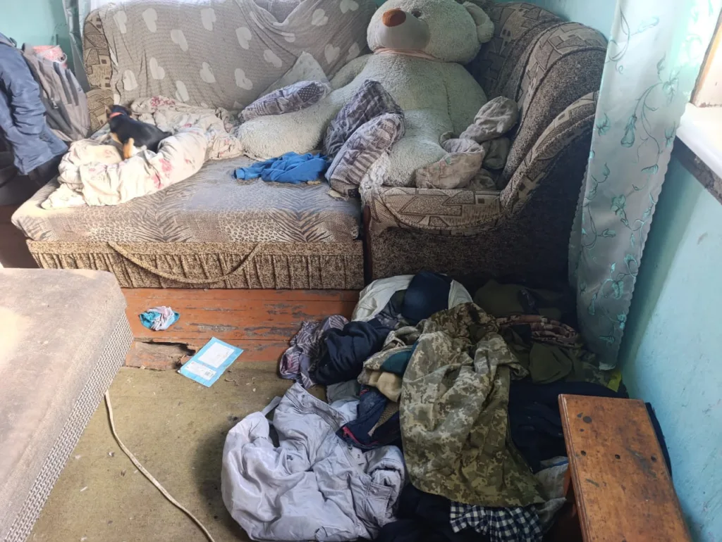 Безладна кімната з диваном і великим плюшевим ведмедем