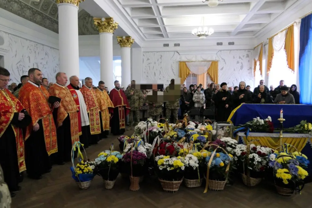 Прощання з загиблим військовим у залі з квітами