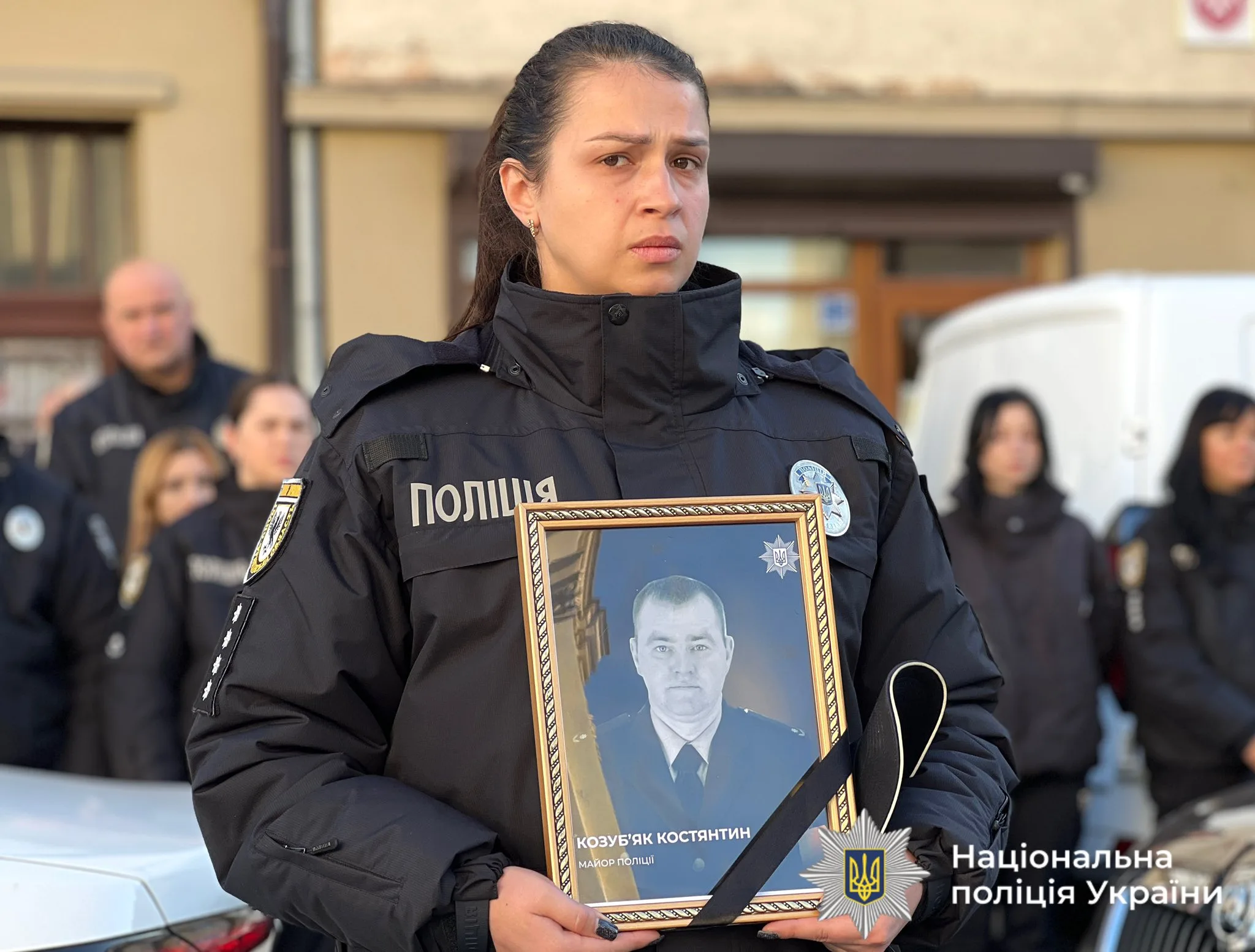 Поліцейська тримає фото загиблого колеги України