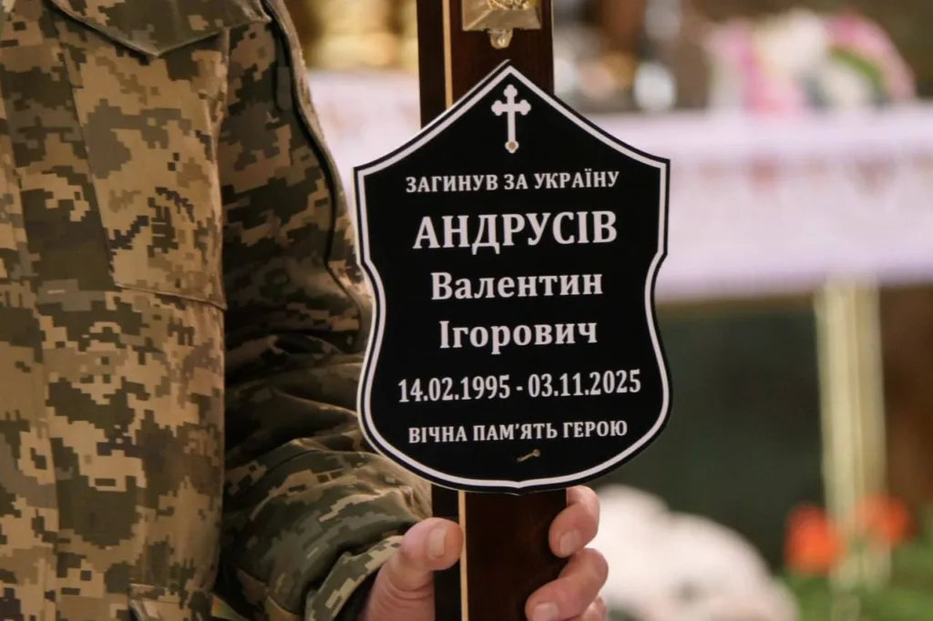 Військовий тримає меморіальну табличку героя