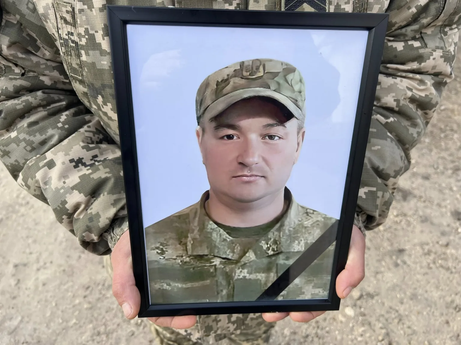 Військовий тримає фото загиблого солдата