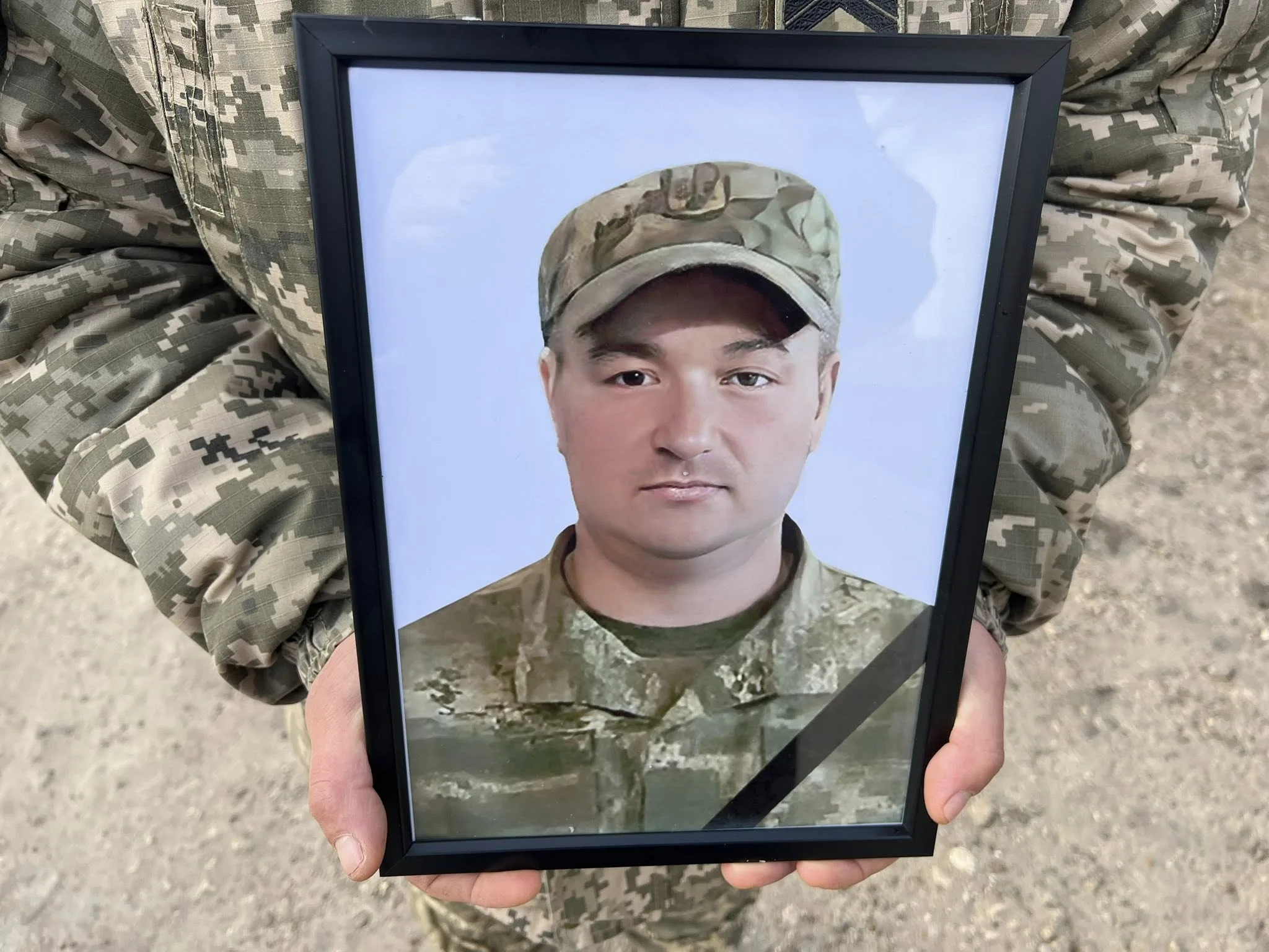 Військовий тримає фото загиблого солдата