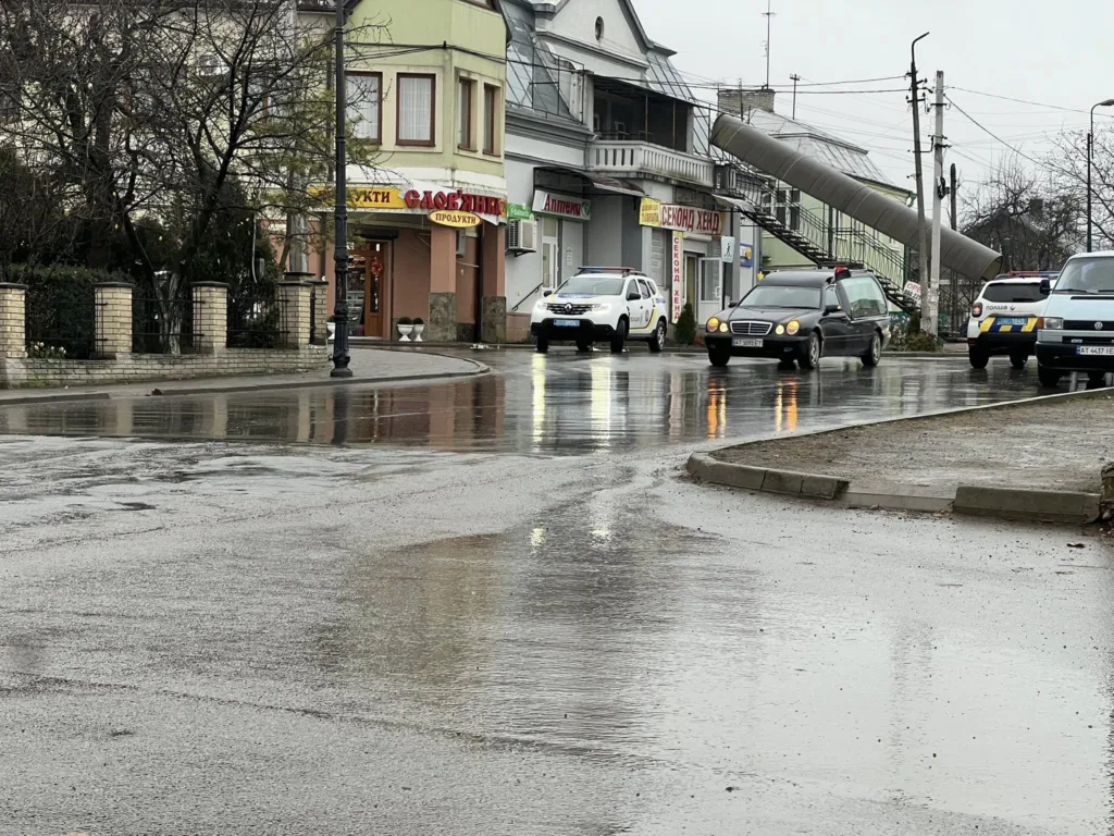 Дощова вулиця з автомобілями та магазинами