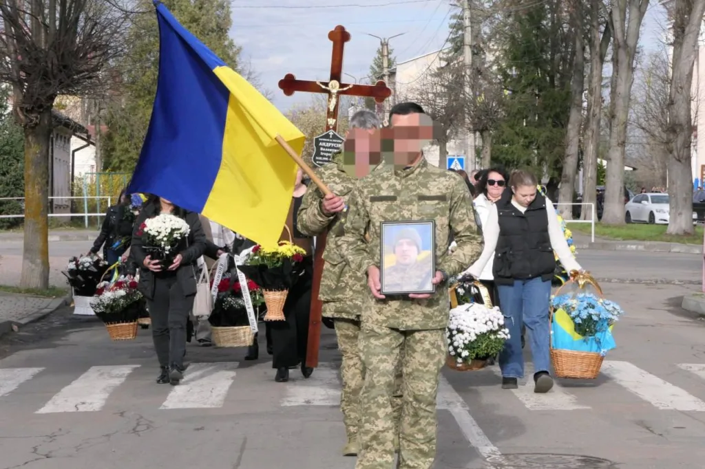 Військові несуть прапор України та квіти