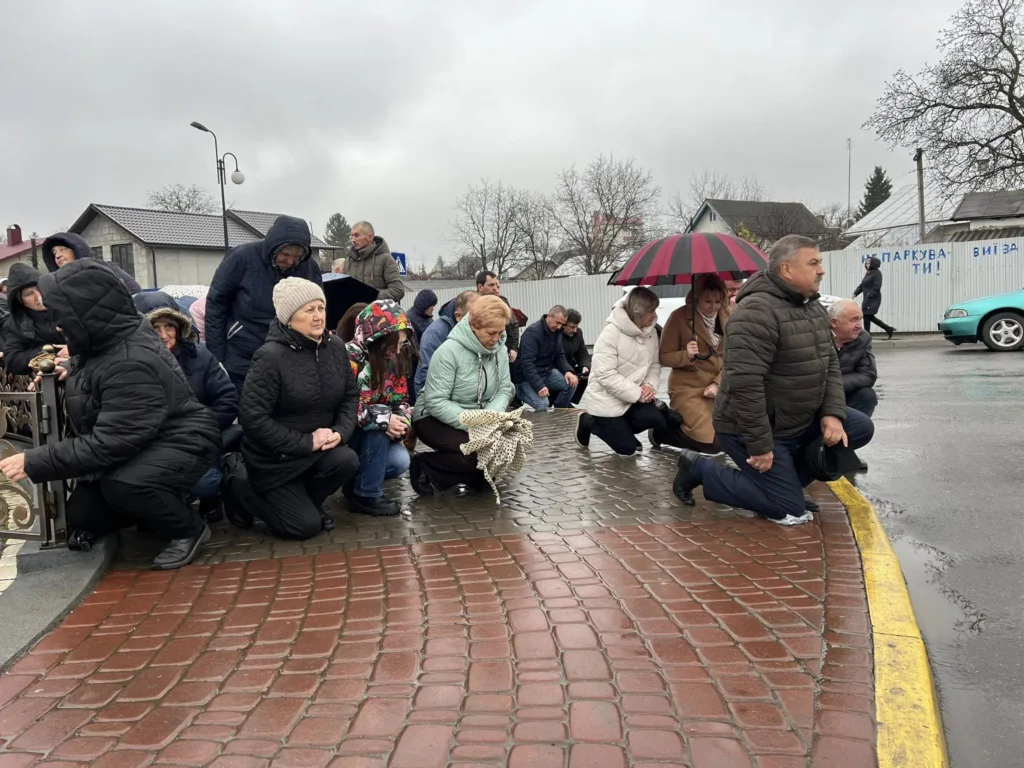 Люди стоять на колінах під час жалобної події