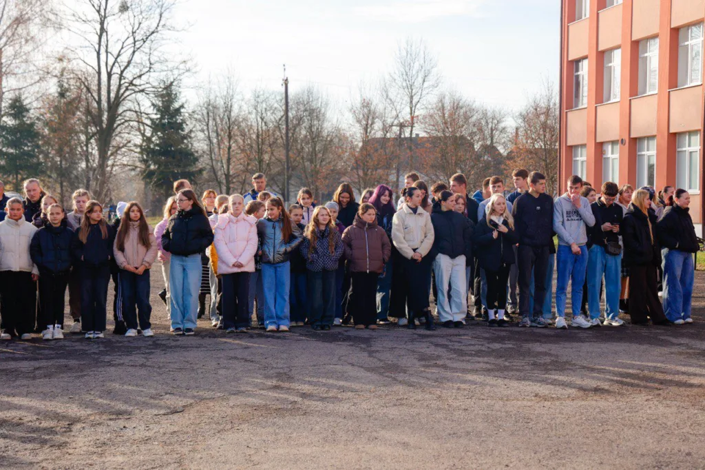 Група учнів стоїть біля шкільної будівлі