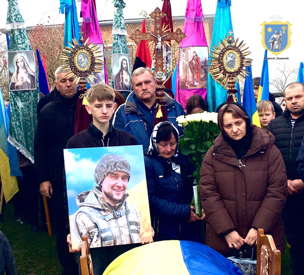 Прощання з українським військовим, люди тримають портрет