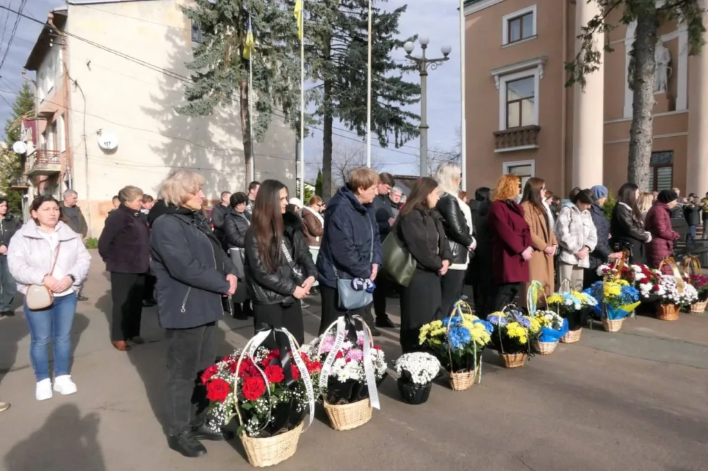 Люди з квітами на меморіальній церемонії