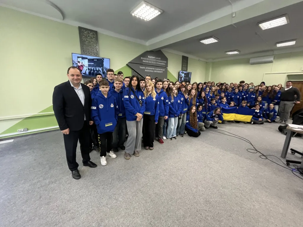 Група студентів у синіх худі з українським прапором