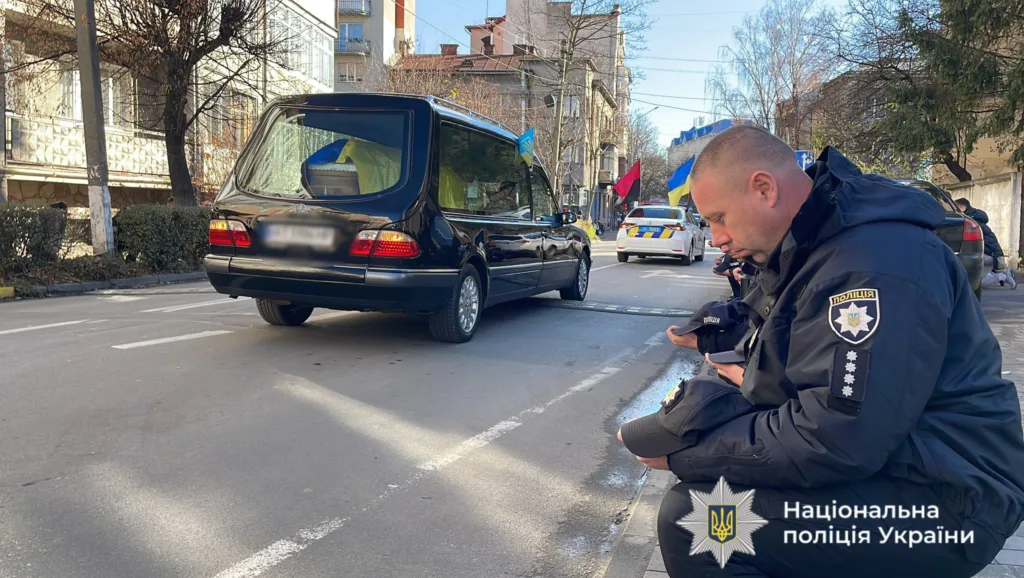 Поліцейський вшановує загиблого колегу під час кортежу