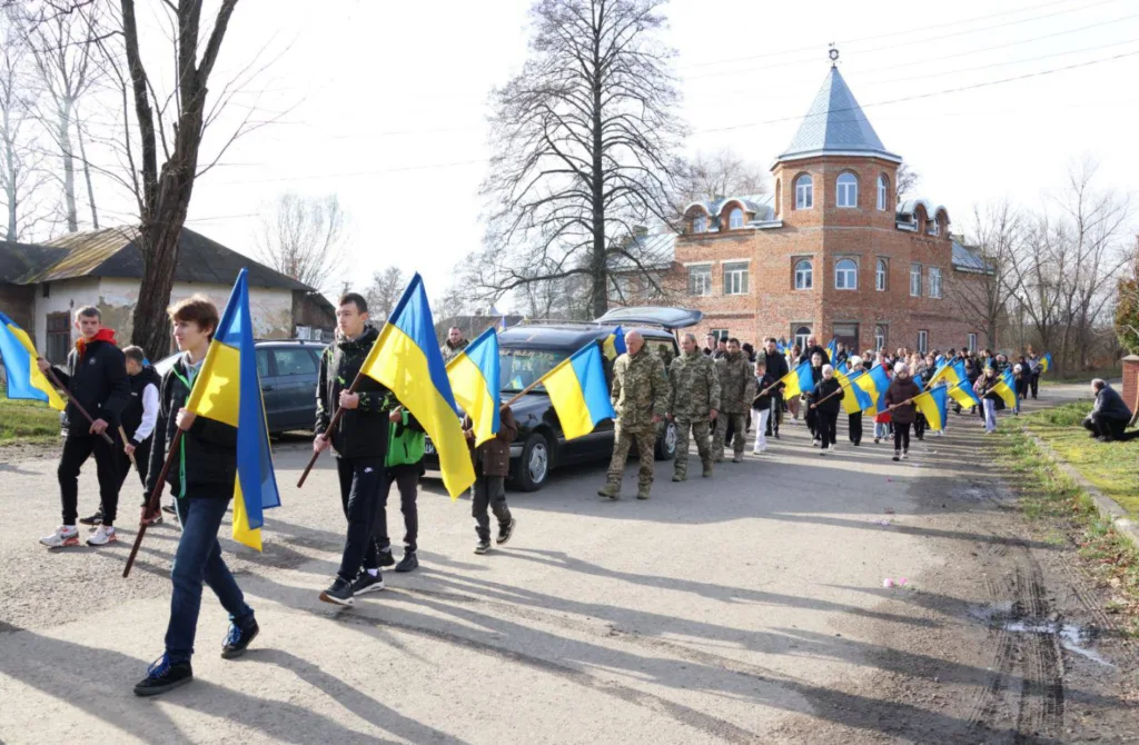 Люди з українськими прапорами на вулиці