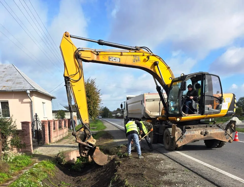 Робітники ремонтують дорогу екскаватором біля будинку