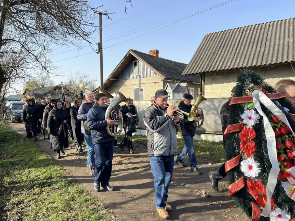 Похоронна процесія з духовим оркестром у селі