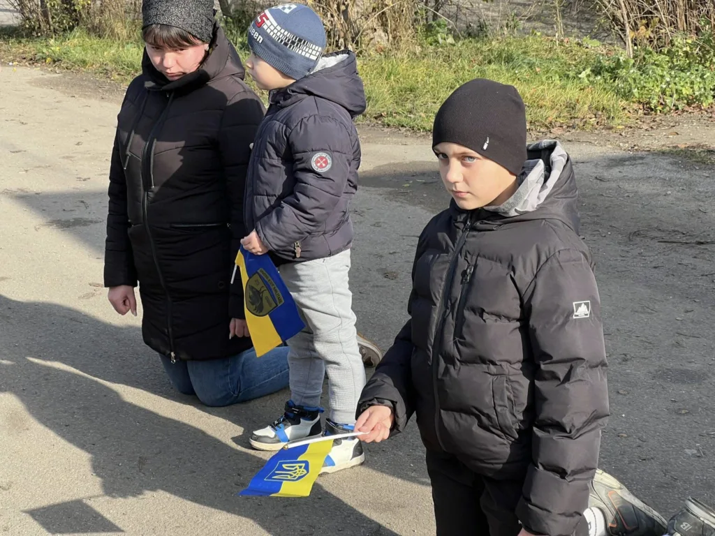 Люди на колінах тримають українські прапори