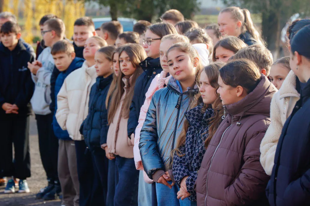 Група школярів стоїть на вулиці восени