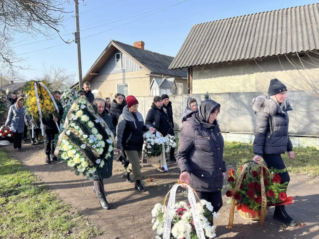 Похоронна процесія з квітами у сільській місцевості