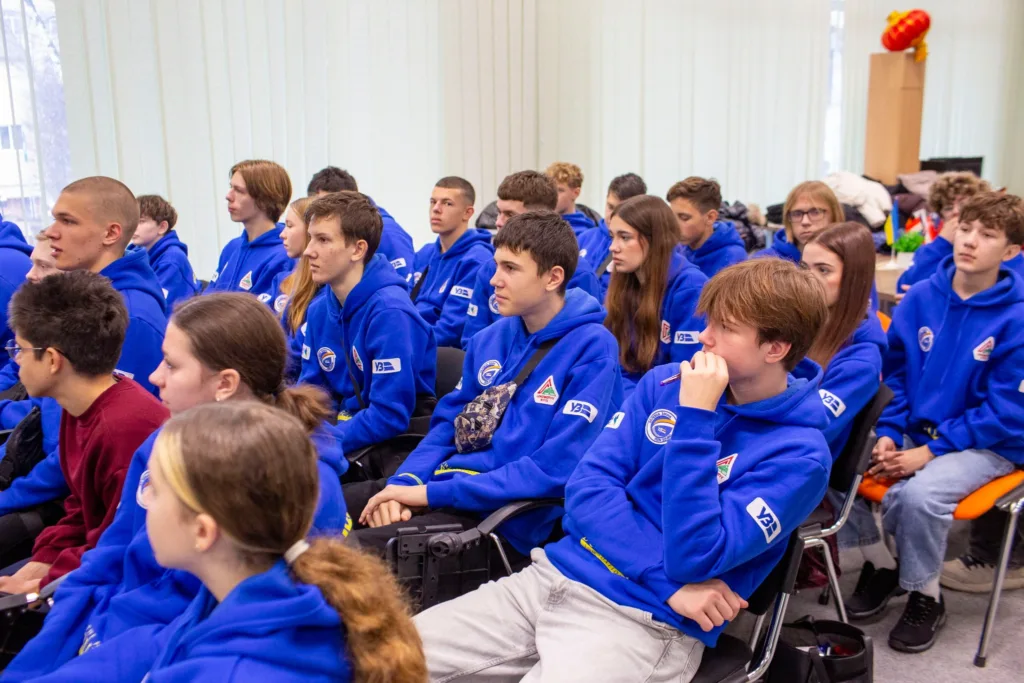 Група студентів у синіх худі на лекції