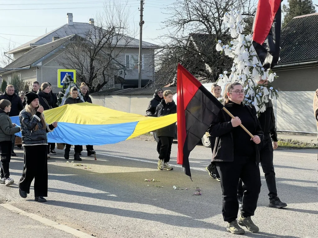 Люди несуть український прапор під час ходи