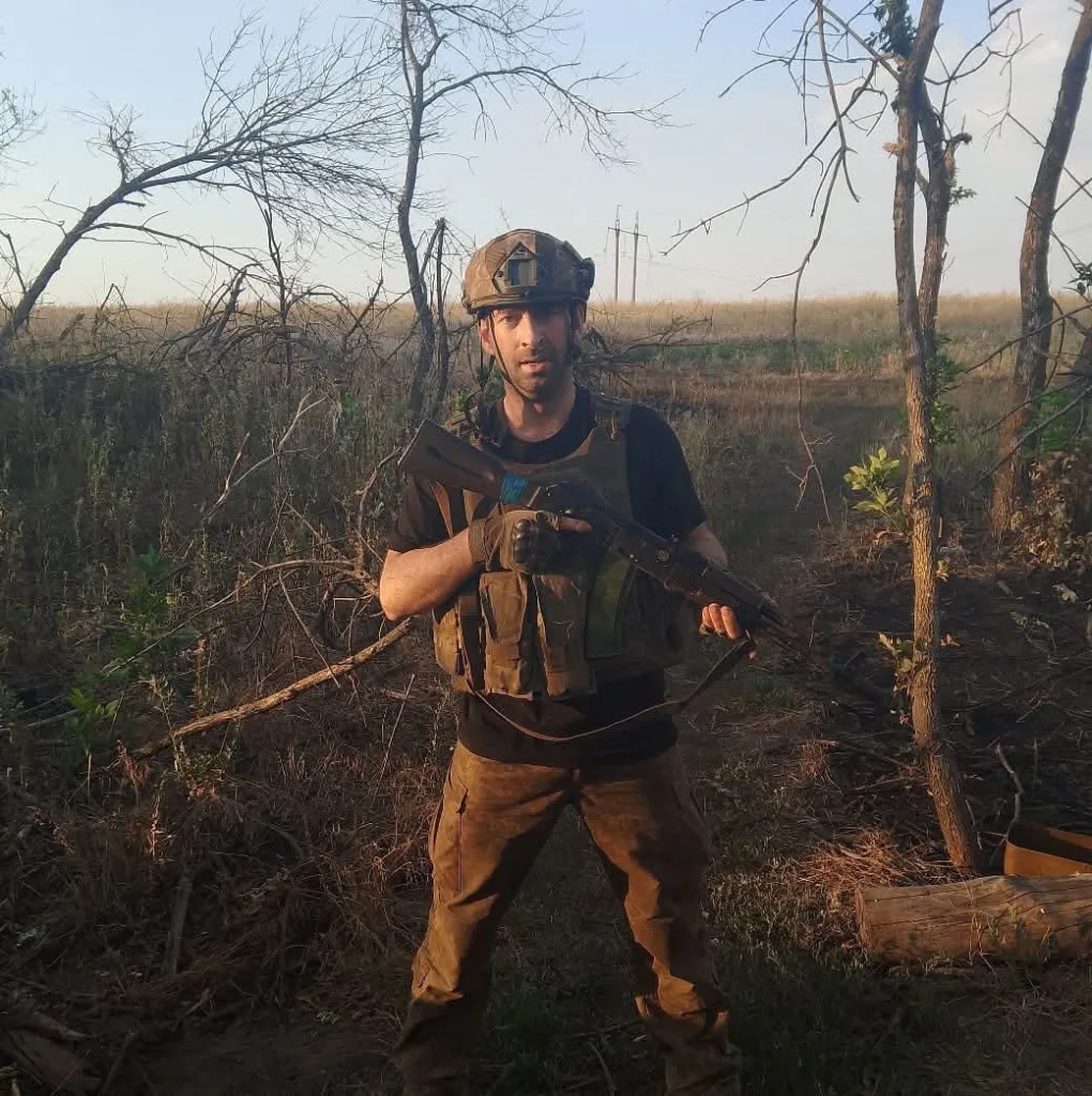 Військовий у формі з автоматом на природі