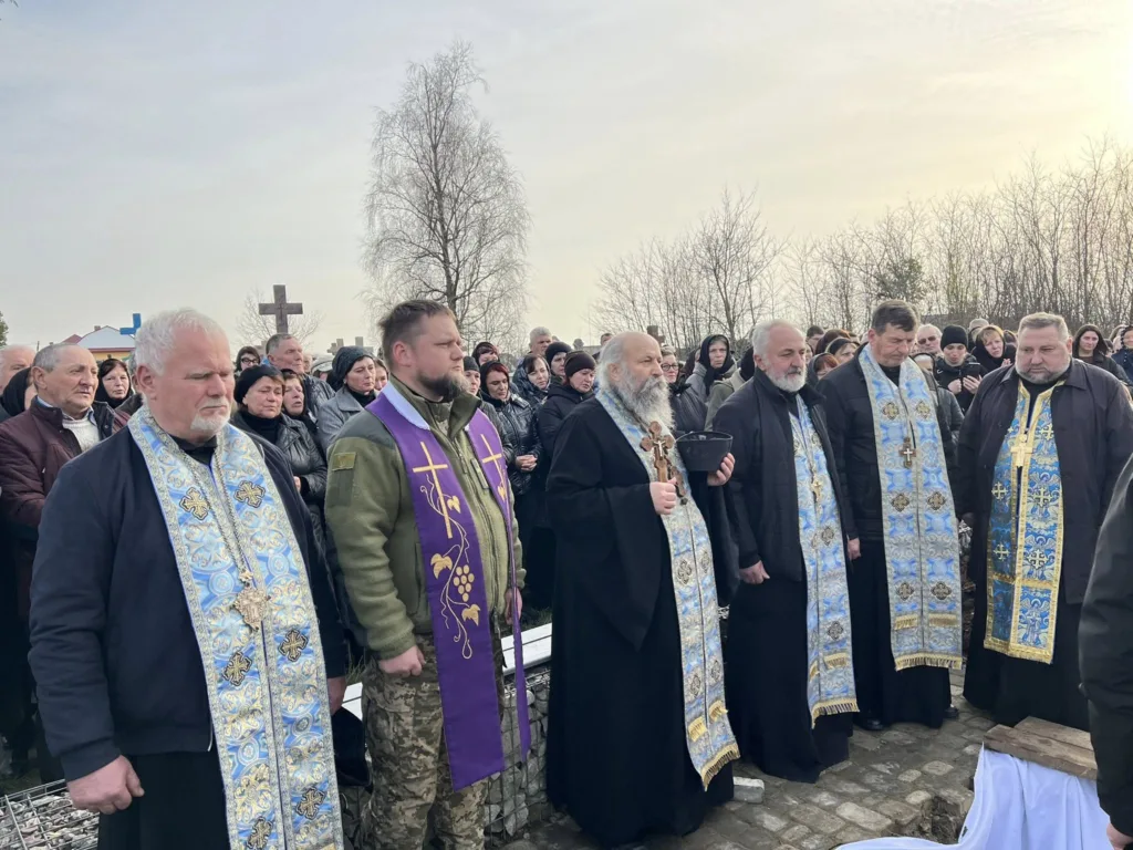 Священники та люди на церемонії на кладовищі