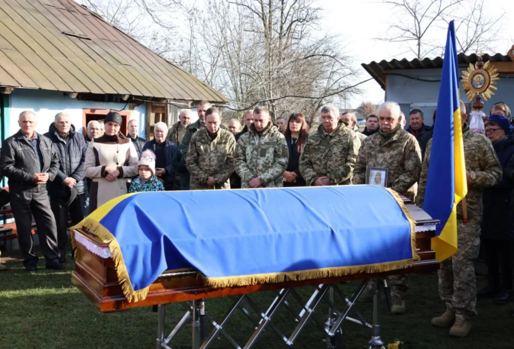 Прощання з українським воїном під державною прапором