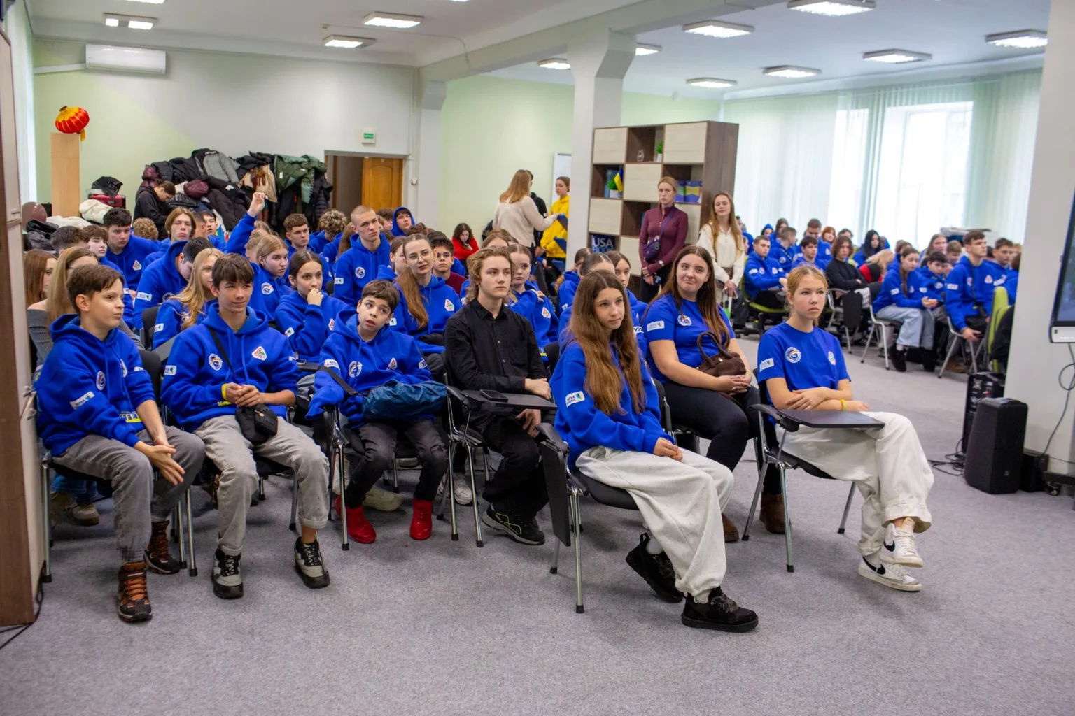 Учні у синіх толстовках на шкільному заході