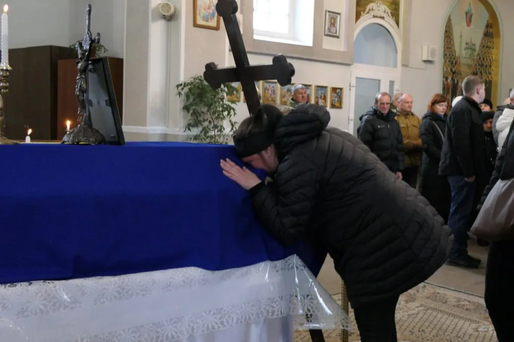 Жінка прощається з покійним у церкві