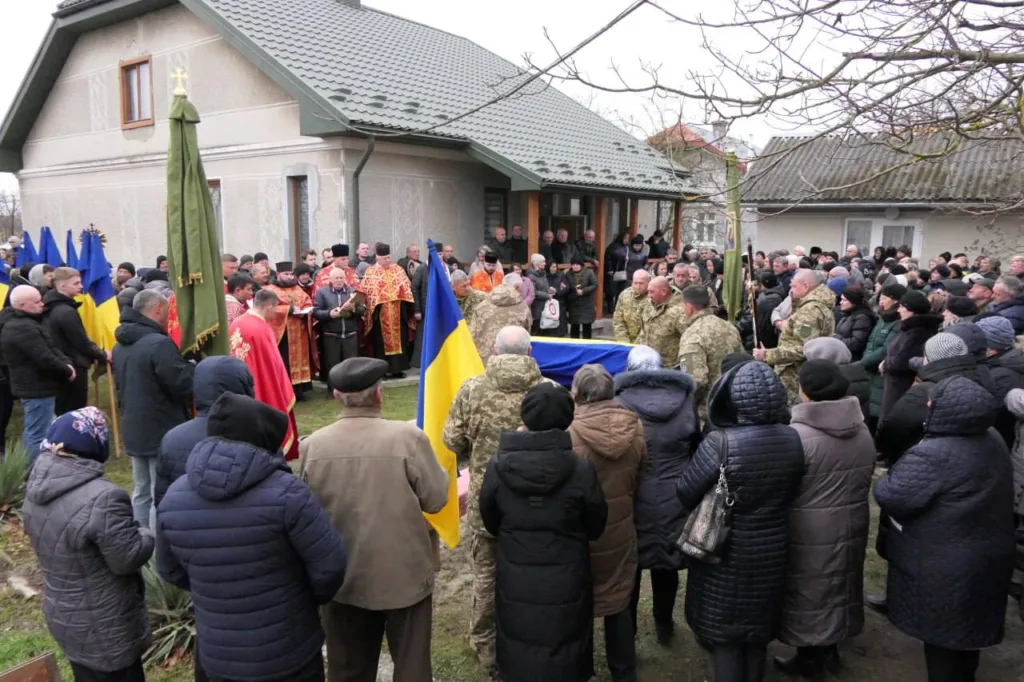 Військові похорони з українськими прапорами біля будинку