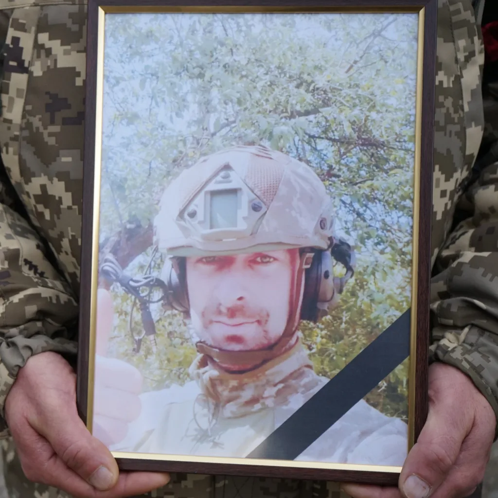 Портрет військового у формі, триманий у руках