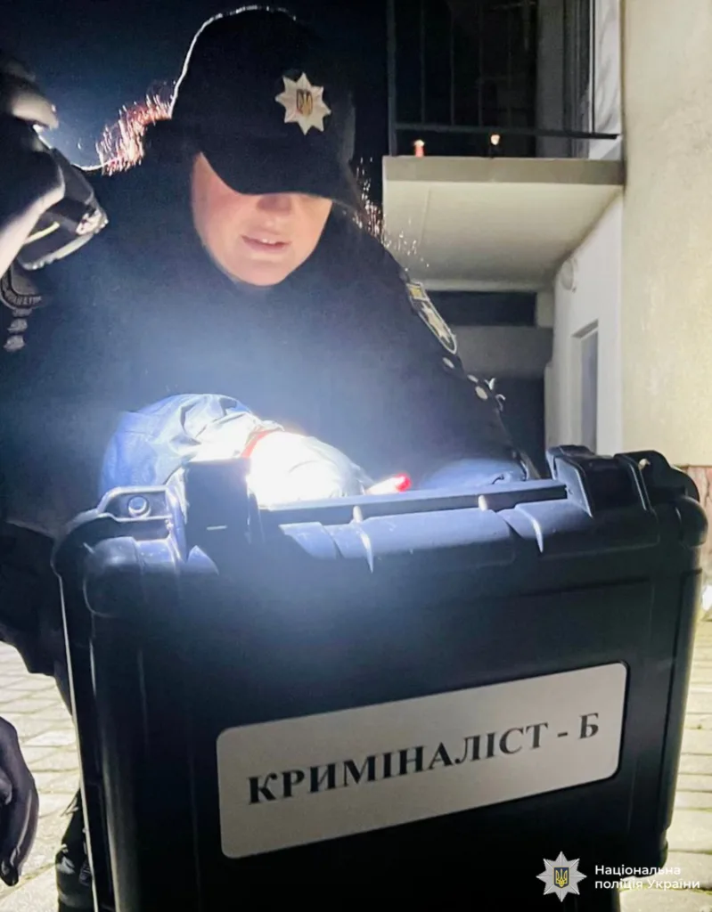 Криміналіст поліції працює з обладнанням на місці події