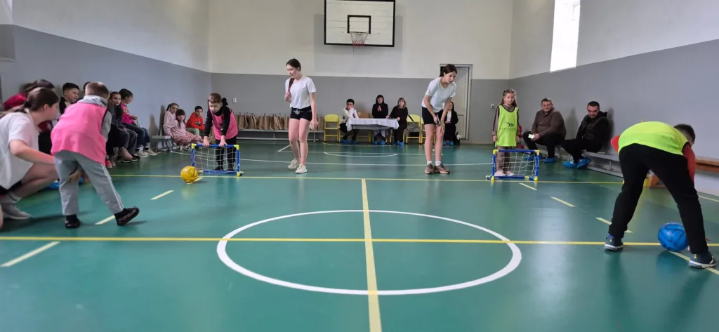 Діти грають у футбол у спортивній залі школи