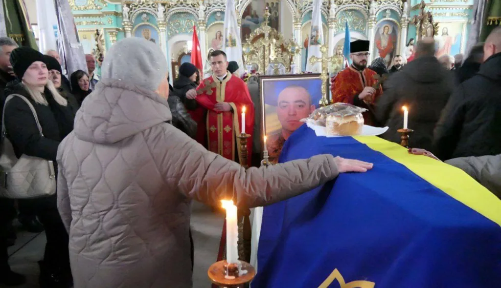 Прощання з військовим у церкві під українським прапором