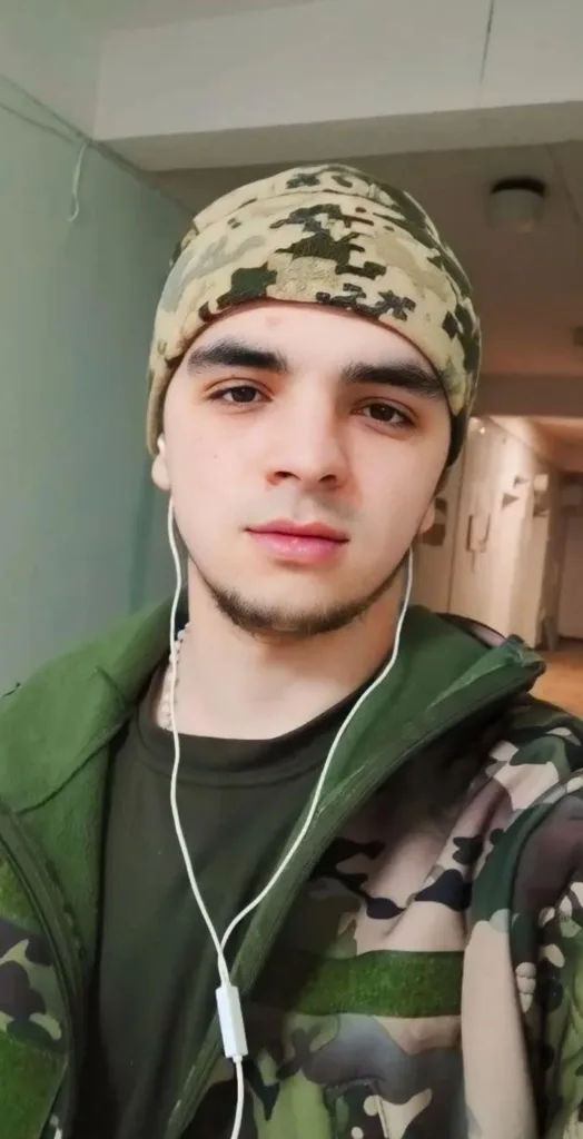 Молодий чоловік у камуфляжі з навушниками